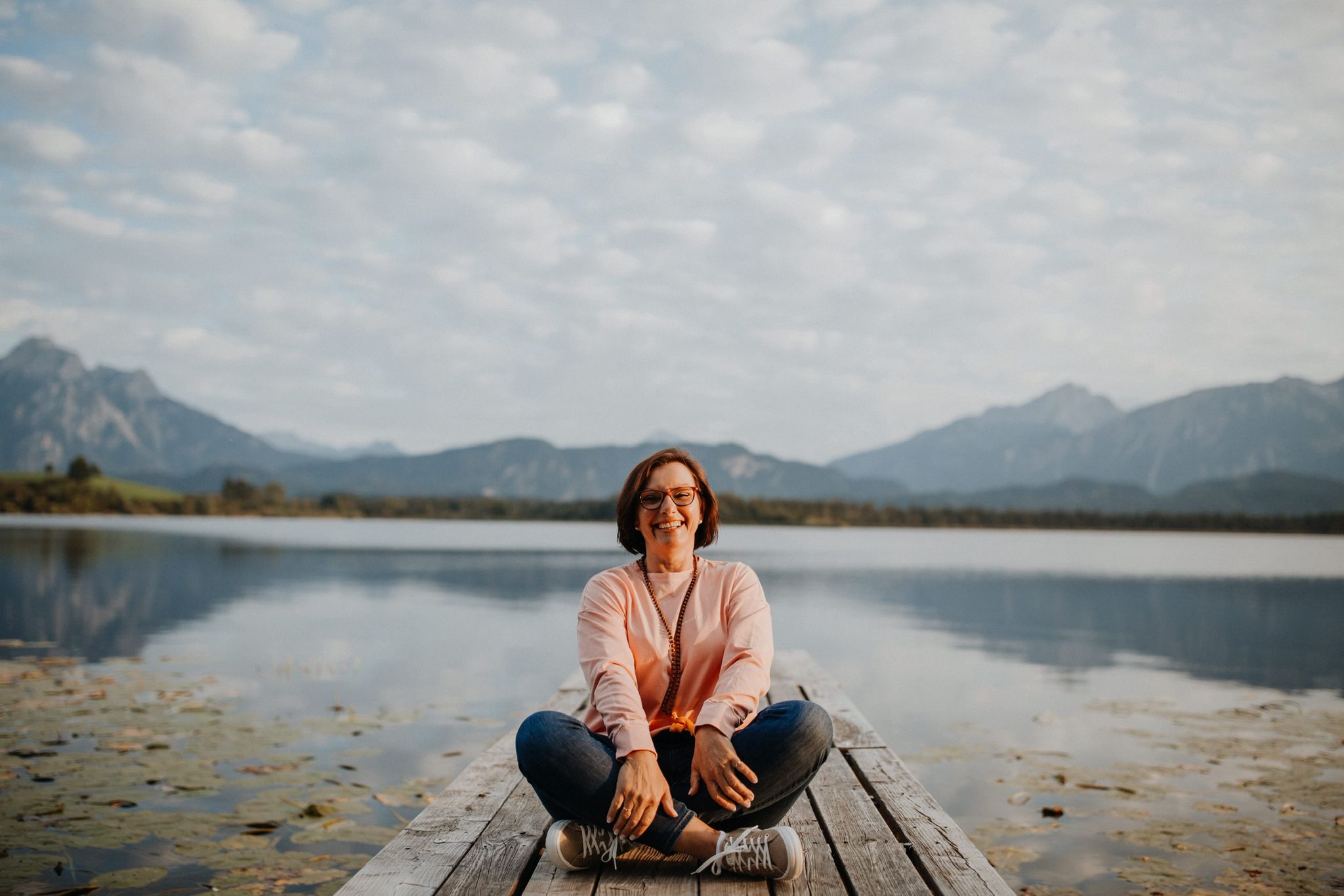 Nicole Schäfer sitzt am See vor den Allgäuer Alpen